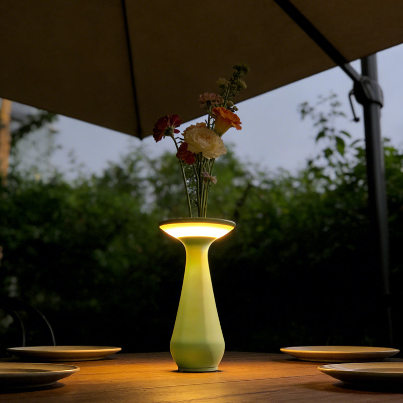 Vase lamp with flowers on a restaurant table at dusk